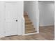 Clean, light-wood stairs with a white door, and wood flooring at 4219 David Austin Ct, Snellville, GA 30039