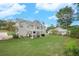 Spacious backyard featuring a large lawn, patio, pergola, and mature trees at 225 Ruby Forest Pkwy, Suwanee, GA 30024