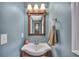 Stylish bathroom features a white sink, wood-framed mirror, updated fixtures and a blue accent wall at 225 Ruby Forest Pkwy, Suwanee, GA 30024
