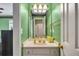 Bathroom featuring a green vanity, a large mirror, and classic lighting at 225 Ruby Forest Pkwy, Suwanee, GA 30024