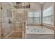 Modern bathroom with walk-in shower, jetted tub, and natural stone accents at 225 Ruby Forest Pkwy, Suwanee, GA 30024
