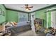 Green bedroom featuring a bed, a desk with a chair, and a window for natural light at 225 Ruby Forest Pkwy, Suwanee, GA 30024