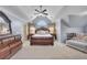 Spacious bedroom with vaulted ceiling, ceiling fan, sitting area, and luxurious furnishings at 225 Ruby Forest Pkwy, Suwanee, GA 30024