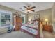 Cozy bedroom featuring a four-poster bed, ceiling fan, and natural light from two windows at 225 Ruby Forest Pkwy, Suwanee, GA 30024