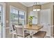 Cozy dining area features a wood table, white chairs, bench seating, and a view to the backyard at 225 Ruby Forest Pkwy, Suwanee, GA 30024