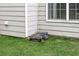 Lawn care is easy with a robotic lawn mower next to the home's exterior at 225 Ruby Forest Pkwy, Suwanee, GA 30024