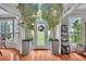 Grand foyer featuring hardwood floors, large potted trees, and a decorative front door at 225 Ruby Forest Pkwy, Suwanee, GA 30024