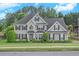 Charming two-story home with a well-manicured lawn, lush greenery, and traditional architectural details at 225 Ruby Forest Pkwy, Suwanee, GA 30024