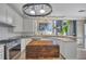 Bright kitchen features white cabinets, stainless steel appliances, a marble countertop and pendant lighting at 225 Ruby Forest Pkwy, Suwanee, GA 30024