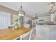 Bright kitchen features white cabinets, stainless steel appliances, a marble countertop and pendant lighting at 225 Ruby Forest Pkwy, Suwanee, GA 30024