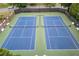 Aerial view of two meticulously maintained tennis courts with green and blue playing surfaces at 225 Ruby Forest Pkwy, Suwanee, GA 30024