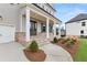 Inviting front porch with brick accents, columns, and landscaped flower beds at 5424 Gallagher Ct, Powder Springs, GA 30127
