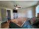 Bedroom features a ceiling fan, a wall-mounted TV, wood floors, and neutral walls at 6567 Post Rd, Douglasville, GA 30135