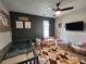 Well-lit Bedroom with grey decor, hardwood floors, crib, a wall-mounted TV, and playroom at 6567 Post Rd, Douglasville, GA 30135