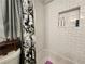 Shower featuring subway tile, recessed shelves, and a decorative curtain at 6567 Post Rd, Douglasville, GA 30135