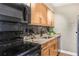 Kitchen featuring black appliances, stone counters, tile backsplash, and wood cabinets at 1150 Collier Nw Rd # D20, Atlanta, GA 30318