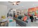 Bright living area with gray sofa, pops of orange/yellow, connected to a modern kitchen and dining area at 320 Navigator Ln, Mcdonough, GA 30253