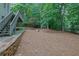 Backyard with stone walls, mature trees, and under-decking area at 4047 Watkins Glen Dr, Woodstock, GA 30189