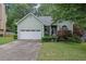 Charming home with a two-car garage and manicured landscaping, lush green lawn, and mature trees at 4047 Watkins Glen Dr, Woodstock, GA 30189