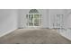 Bright living room features large windows, plush carpet, and staircase leading to the upper level at 4047 Watkins Glen Dr, Woodstock, GA 30189