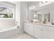 Bathroom featuring a bathtub and a double vanity with quartz countertops at 4060 Andover Cir, Mcdonough, GA 30252