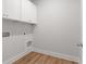 A well-lit, compact laundry room with white cabinetry and modern fixtures at 4060 Andover Cir, Mcdonough, GA 30252