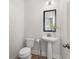 Simple powder room with a pedestal sink, toilet, and framed mirror at 4060 Andover Cir, Mcdonough, GA 30252