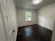 Cozy bedroom features gleaming hardwood floors, neutral walls, and a window for natural light at 5460 Huron Dr, Morrow, GA 30260