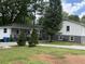 Exterior view of the house showing white siding, a deck, and mature trees at 5460 Huron Dr, Morrow, GA 30260