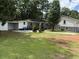 View of the home featuring a carport, small deck, and well-maintained lawn at 5460 Huron Dr, Morrow, GA 30260