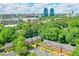 Aerial view of townhomes with lush green trees and the city in the background at 701 Dunwoody Chace, Atlanta, GA 30328