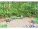 Secluded gravel backyard patio area surrounded by lush landscaping with outdoor seating at 701 Dunwoody Chace, Atlanta, GA 30328
