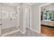 Modern bathroom featuring tiled shower, decorative floor, and open doorway to bedroom at 701 Dunwoody Chace, Atlanta, GA 30328