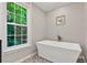 Elegant bathtub with sleek fixtures, decorative tile floor, and sunlit window at 701 Dunwoody Chace, Atlanta, GA 30328