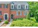 Charming red brick townhome featuring a well-maintained yard and classic architectural details at 701 Dunwoody Chace, Atlanta, GA 30328