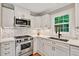 Stylish kitchen featuring white cabinets, stainless steel appliances, and a mosaic backsplash at 701 Dunwoody Chace, Atlanta, GA 30328