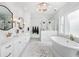 Elegant bathroom features a freestanding tub, chandelier, double vanity and glass shower with marble tile at 1445 Hillside Dr, Grayson, GA 30017
