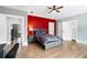Bedroom featuring hardwood floors and a bold red accent wall at 1445 Hillside Dr, Grayson, GA 30017