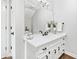 Charming half bath featuring white cabinets, black hardware, and decorative elements at 1445 Hillside Dr, Grayson, GA 30017
