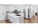 Modern kitchen featuring stainless steel appliances, white cabinets, subway tile backsplash and hardwood floors at 1445 Hillside Dr, Grayson, GA 30017