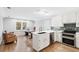 Eat-in kitchen featuring stainless steel appliances, white cabinets, breakfast bar, and adjacent living room at 1445 Hillside Dr, Grayson, GA 30017