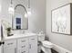 Stylish powder room with white vanity, framed mirror, and modern lighting fixtures at 1445 Hillside Dr, Grayson, GA 30017