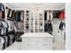 Spacious walk-in closet with custom shelving, drawers, and central island topped by a decorative chandelier at 1445 Hillside Dr, Grayson, GA 30017