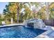 Beautiful waterfall cascading into a crystal-clear swimming pool, creating a tranquil and picturesque outdoor oasis at 1445 Hillside Dr, Grayson, GA 30017