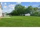 Expansive backyard featuring a lush lawn, mature trees, and a detached garage at 2284 Briarwood Cir, Conyers, GA 30094