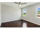 Bright bedroom with a ceiling fan, hardwood floors, and windows looking out to the yard at 2284 Briarwood Cir, Conyers, GA 30094