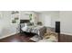 Cozy bedroom featuring hardwood floors, a ceiling fan, a large window, and stylish decor at 2284 Briarwood Cir, Conyers, GA 30094