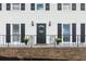 View of the home's entry featuring a black door with a wreath, plants, and black railing at 2284 Briarwood Cir, Conyers, GA 30094