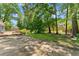 A sprawling backyard with a patio and a wooden deck surrounded by lush greenery and trees at 3770 Clubland Trl, Marietta, GA 30068