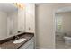 This bathroom includes a granite countertop, a bright mirror, and soft wallpaper for an elegant aesthetic at 3770 Clubland Trl, Marietta, GA 30068